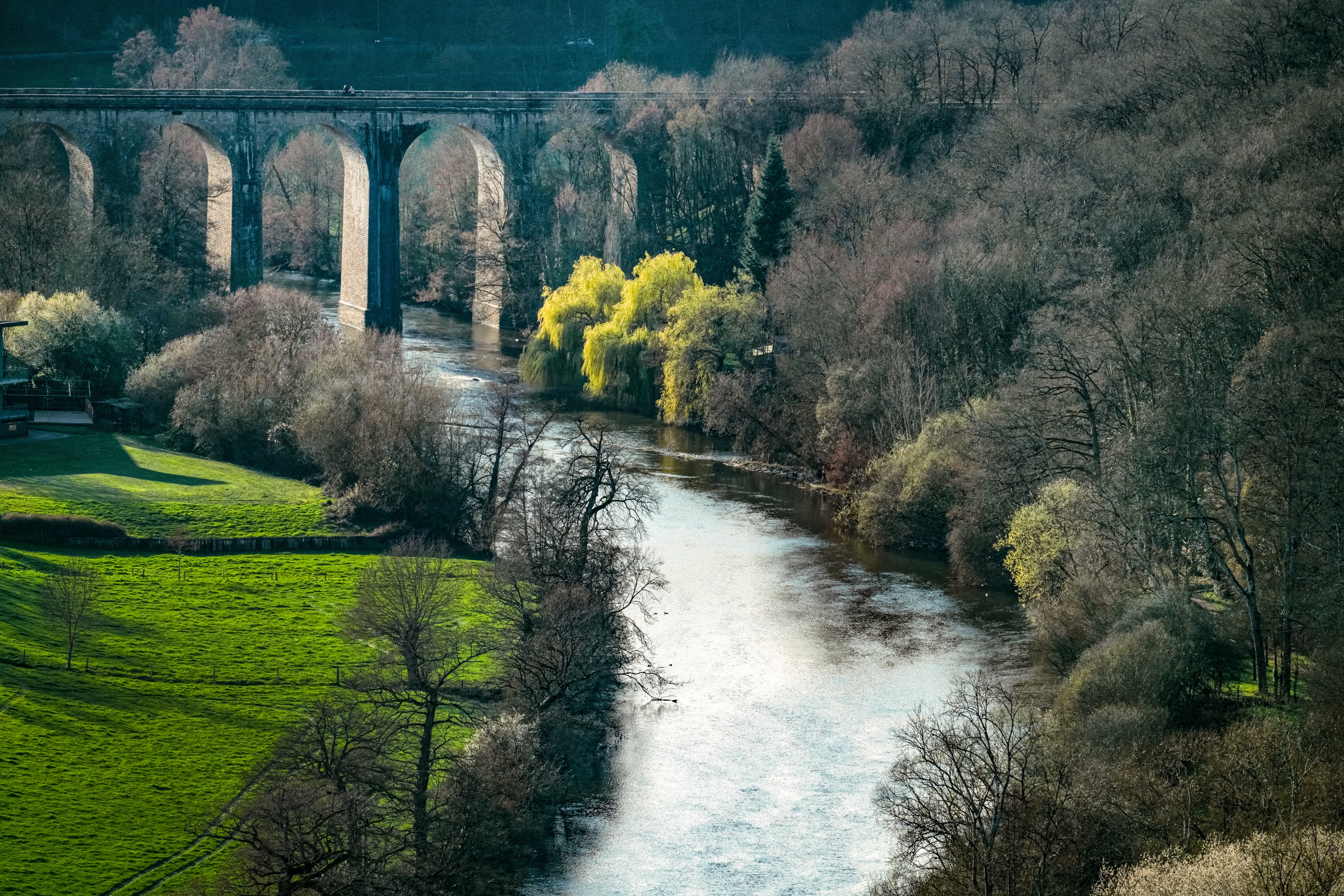 Viaduc de Clécy au-dessus de la rivière Orne, paysage verdoyant en fin d'hiver Normandie avec bourgeons naissants